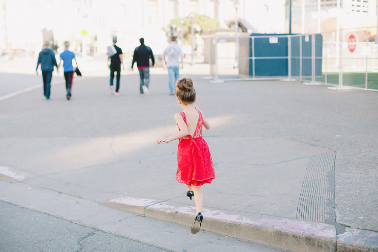 little girl jumping onto the sidewalk in san francisco during photoshoot