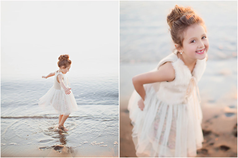 little girl twirling in water at the beach