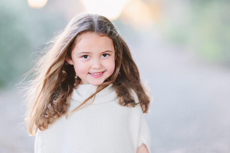 modeling headshot of young girlsmiling in white sweater