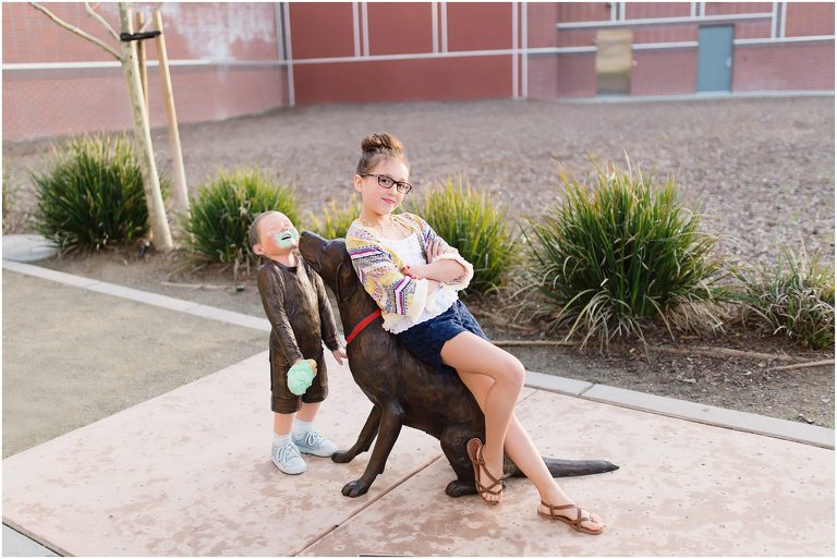 Child poses on dog statue in downtown Livemore outside of Cream