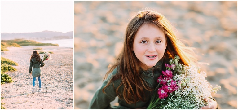 Beautiful little girl smiling for portrait in the sand on the beach in Carmel