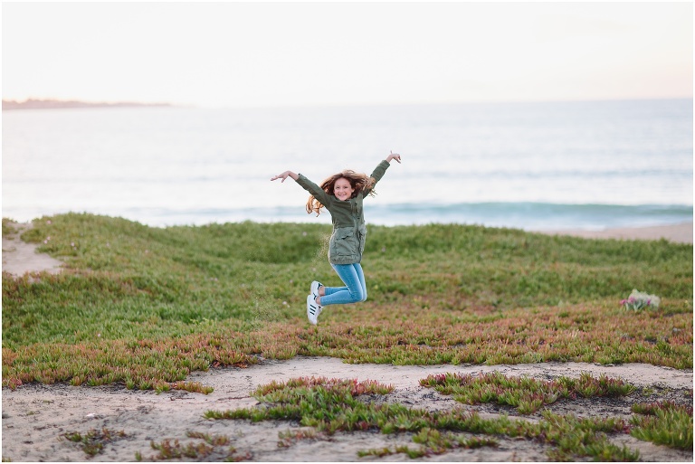 little girl jumping for joy on the beach in Carmel California