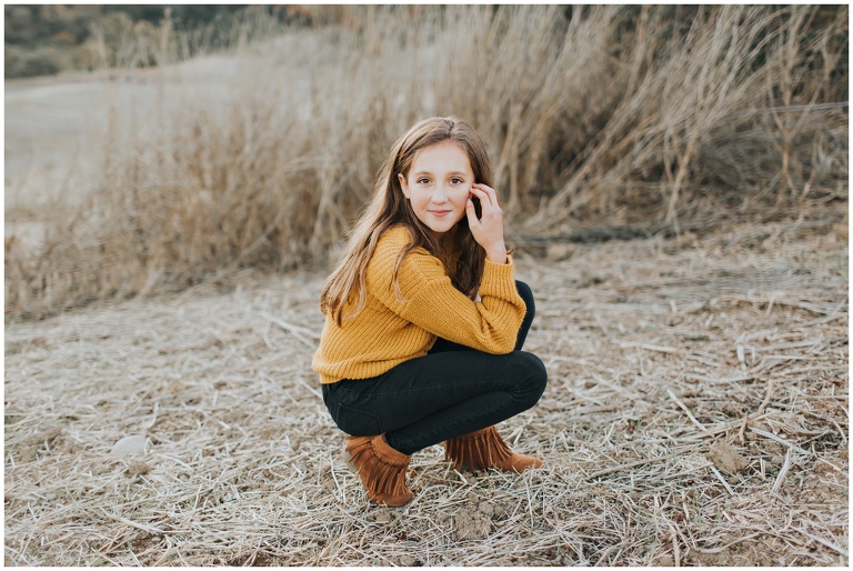 tween girl posing in mustard sweater and black jeans